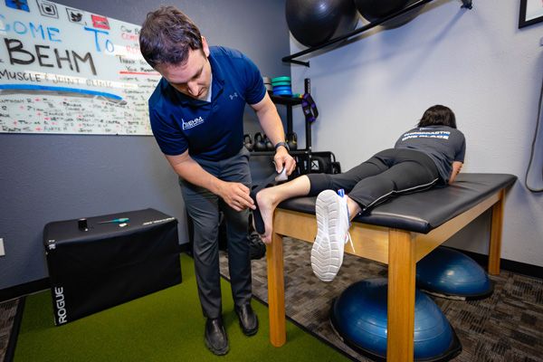 chiropractor applying rocktape to a foot